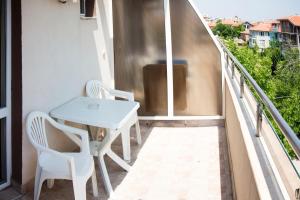 een balkon met een witte tafel en 2 stoelen bij Ivatea Family Hotel in Ravda