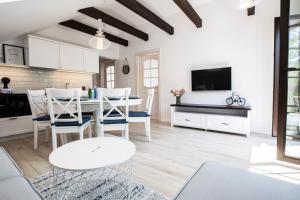 Una cocina y un comedor con mesa y sillas. en Ambre Apartments, en Łeba