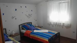 a bedroom with a bed with butterflies on the wall at Tomek Apartment in Vir