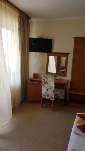 a bedroom with a mirror and a desk and a chair at Guest House Markovi Aheloy in Aheloy