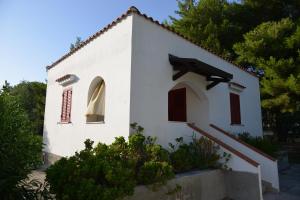 a white church with red shuttered windows and trees at Canto delle Rane in Vieste