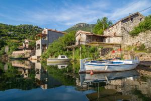 a boat sitting in the water next to buildings at Paradise House Skadar Lake in Karuč