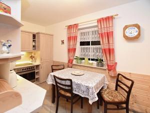 eine Küche mit einem Tisch und Stühlen sowie einem Fenster in der Unterkunft Apartment with views of the Ore Mountains in Oelsnitz