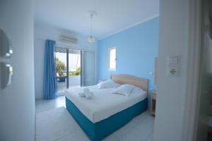 Dimitra Apartment Hotel في سكافيديا: غرفة نوم زرقاء مع سرير ونافذة
