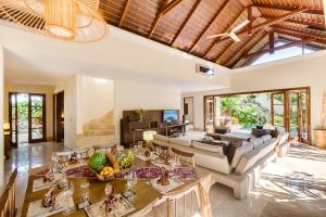 an open living room with a couch and a table at Ungasan Beach Villas in Uluwatu
