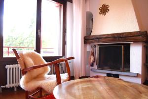 uma sala de estar com uma mesa e uma cadeira e uma televisão em Stylish & Cozy, Préfleuri em Crans-Montana