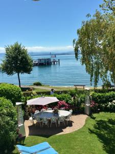 een tafel met parasols naast een waterlichaam bij Boutique Hotel Villa am See in Hagnau