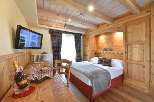 una camera con letto e TV a schermo piatto di Hotel Miravidi a Cervinia a Breuil-Cervinia