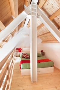 2 letti in una camera mansardata con soffitti in legno di Albergo Diffuso Sauris in Sauris di Sotto a Sauris
