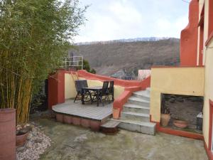 een patio met een tafel en stoelen en een open haard bij Charming Holiday Home in Neumagen Dhron in Neumagen-Dhron