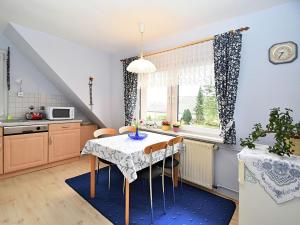 a kitchen with a table and chairs in a room at Holiday home in the Thuringian Forest in Seligenthal