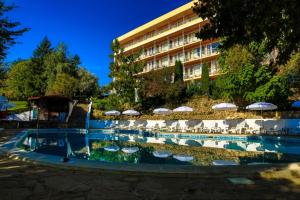 una piscina con sillas y sombrillas frente a un hotel en Vezhen Hotel - Free Parking, en Golden Sands