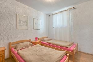 a room with two beds and a window at Apartments Veruda Porat in Pula