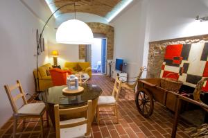 a living room with a table and a cart in it at Casa do Poço in Olhão
