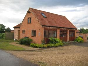 ein Backsteinhaus mit rotem Dach in der Unterkunft Woodlands Holiday Homes in South Clifton