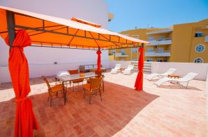 a patio with a table and chairs under a canopy at Casa do Poço in Olhão