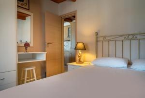 a bedroom with a bed and a table and a lamp at Fiore Beach Studios in Vasilikos