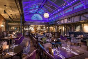 un restaurante con iluminación púrpura, mesas y sillas en The Admiral Rodney Hotel, Horncastle, Lincolnshire, en Horncastle