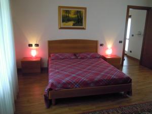 una camera da letto con un letto e due lampade su due tavoli di B&B Emma a Torreano