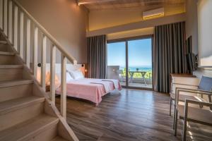 a bedroom with a bed and stairs with a view at Fiore Beach Studios in Vasilikos