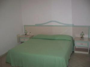 a bedroom with a green bed and two night stands at Hotel Residence La Fortezza in San Lucido +29 photos