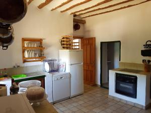 cocina con nevera blanca y fogones en Cortijo Romero en Venta de Micena