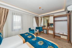 a hotel room with two beds and a desk at Byzantium Comfort Hotel in Istanbul