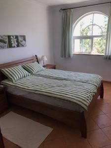 1 cama en un dormitorio con ventana en Tavira Garden- 2 bedrooms-2pools-2 balconies, en Tavira