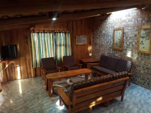 a living room with benches and tables and a tv at Rainbow Lodge in Belfast