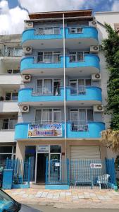 a blue building with a sign in front of it at Ivanovi Guest House in Primorsko