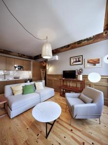 ein Wohnzimmer mit einem weißen Sofa und einem Tisch in der Unterkunft Aparthotel Oporto Batalha in Porto