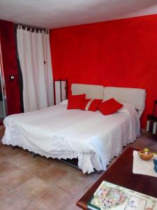 a bedroom with a white bed with red walls at Bed & Relax Sinestesia in Precicchie