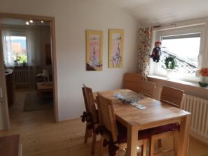 a dining room with a wooden table and a window at Haus Maruna in Schauenburg