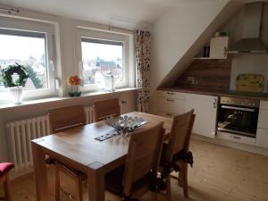 a kitchen with a wooden dining room table with chairs at Haus Maruna in Schauenburg