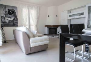 a living room with a white chair and a desk at Villa Il Roseto Redinoce in Procchio