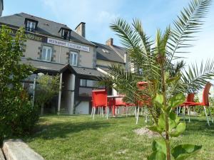 un grupo de sillas rojas frente a un edificio en Hotel Beau Rivage, en Le Vivier-sur-Mer