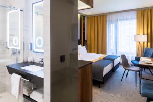 a hotel room with a bed and a bathroom at Grand Ascot Hotel in Krakow