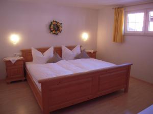 a bedroom with a large bed with white sheets and pillows at Gästehaus Dornach in Oberstdorf