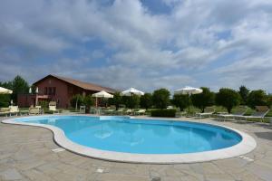a large swimming pool with chairs and umbrellas at Tenuta Monterosso in Feriole
