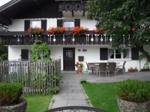 a white house with a balcony with flowers on it at Gästehaus Dornach in Oberstdorf