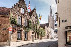 an empty street in an old town with a cathedral at Boutique Hotel De Castillion - Small elegant family hotel in Bruges