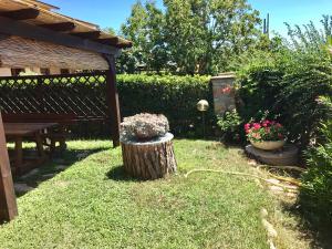 カパルビオにあるLa Fontanella del Giardinoの木の切り株とベンチと花の庭園