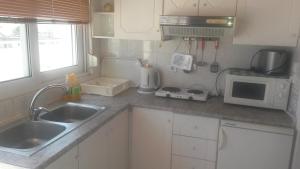 a small kitchen with a sink and a microwave at Elite Apartments in Kos