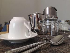 a table with a white cup and a plate and spoons at B&B Il Prugnolo in Castel di Sangro