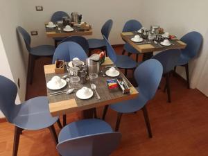 a dining room with blue chairs and tables with food on them at B&B Il Prugnolo in Castel di Sangro