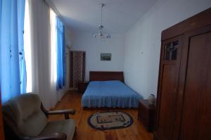 sypialnia z łóżkiem i krzesłem w pokoju w obiekcie Lelis Guest House w mieście Sighnaghi