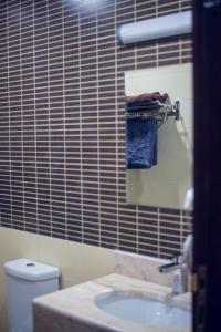 bagno con lavandino, servizi igienici e specchio di Khan Saray a As Sulaymānīyah