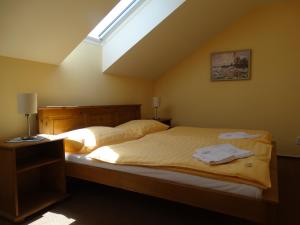 Schlafzimmer mit einem großen Bett und einem Dachfenster in der Unterkunft Penzion Poříčí in Trutnov