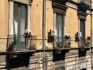 a building with balconies with flowers on them at Dimora Umberto in Catania