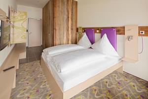 سرير أو أسرّة في غرفة في Explorer Hotel Hinterstoder